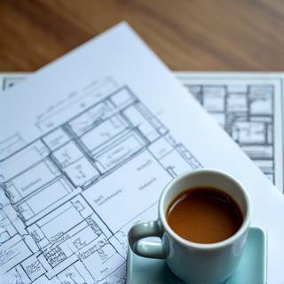 Architectural blueprints and a coffee cup.